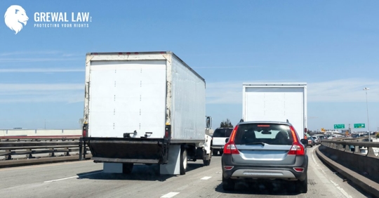 POV of a car driving behind an SUV and an 18-wheeler